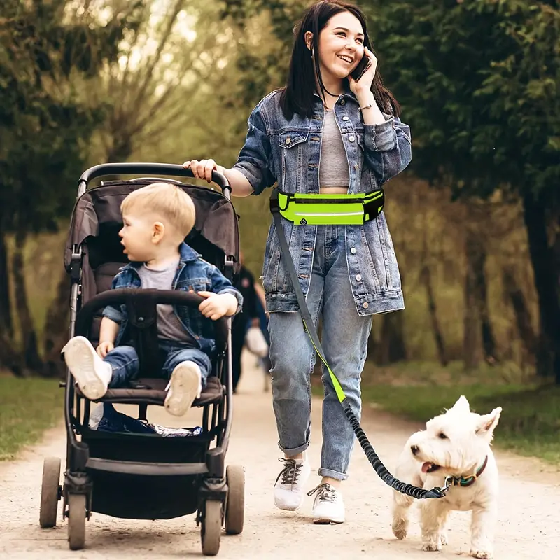 Femme se promenant avec son chien et son garçon dans un parc avec la laisse FreeLeash™ Femme se promenant avec son chien et son garçon dans un parc avec la laisse FreeLeash™